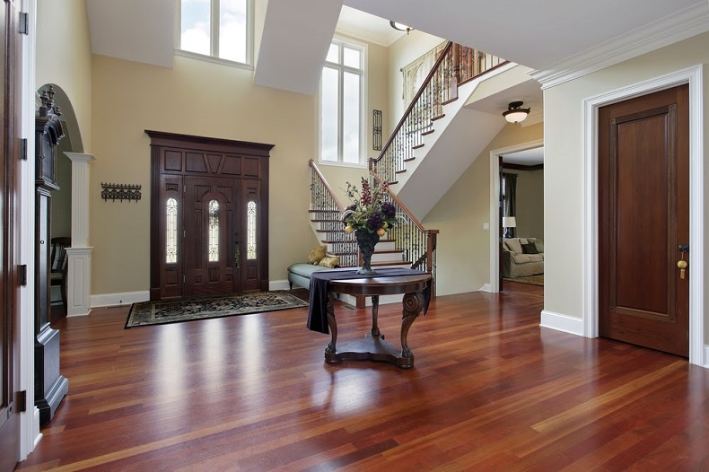 A foyer with hardwood floors and a staircase.