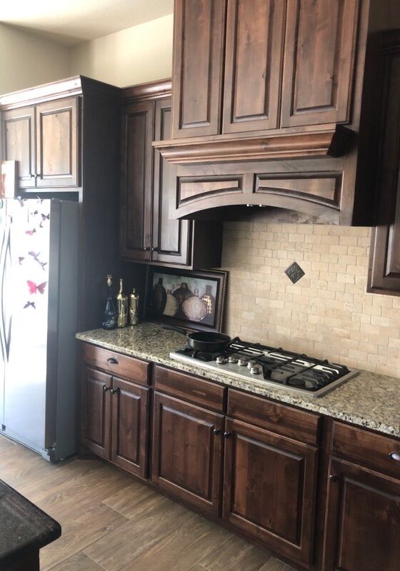 A kitchen with brown cabinets and granite counter tops.